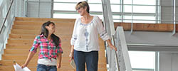 Two women walking down stairs and talking